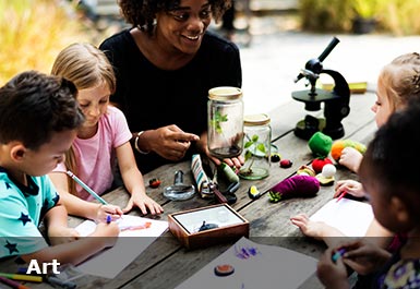 teacher and pupils making art at a table