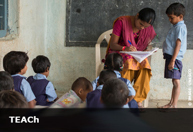 Class outside woman teaching a boy