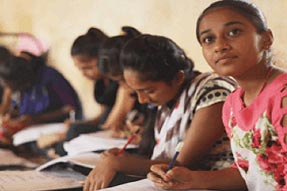 Girls sitting on floor studying in a classroom India