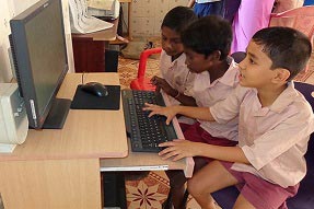 Three students on the computer in primary school in Tamil Nadu India