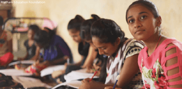 Girls sitting on floor studying in a classroom India