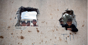 Boys playing on shelled wall