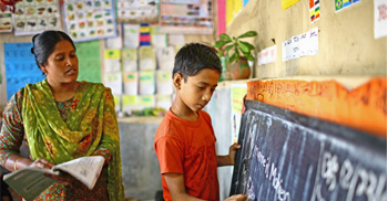 Teacher and student in classroom at board