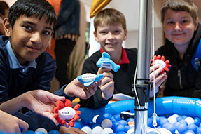 A group of school boys showing things they have made