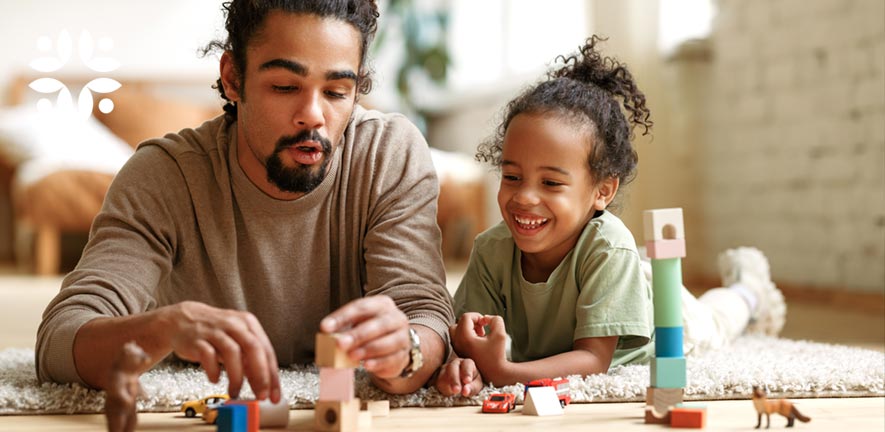 Imaginery play - a dad with building blocks toy cars and figures playing with his daughter on the living room floor