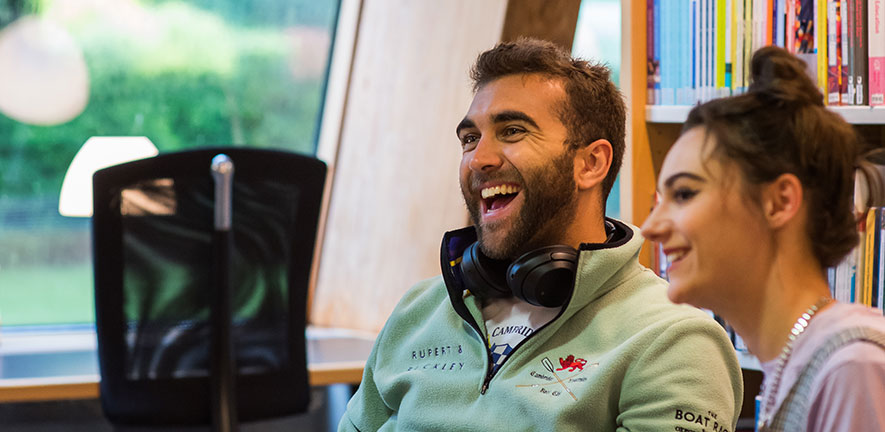 Two students in class laughing and looking happy