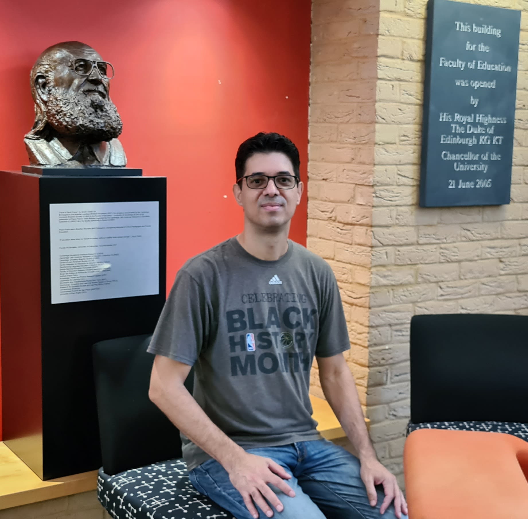 Amilcar with the bust of Paulo Freire at the Faculty of Education