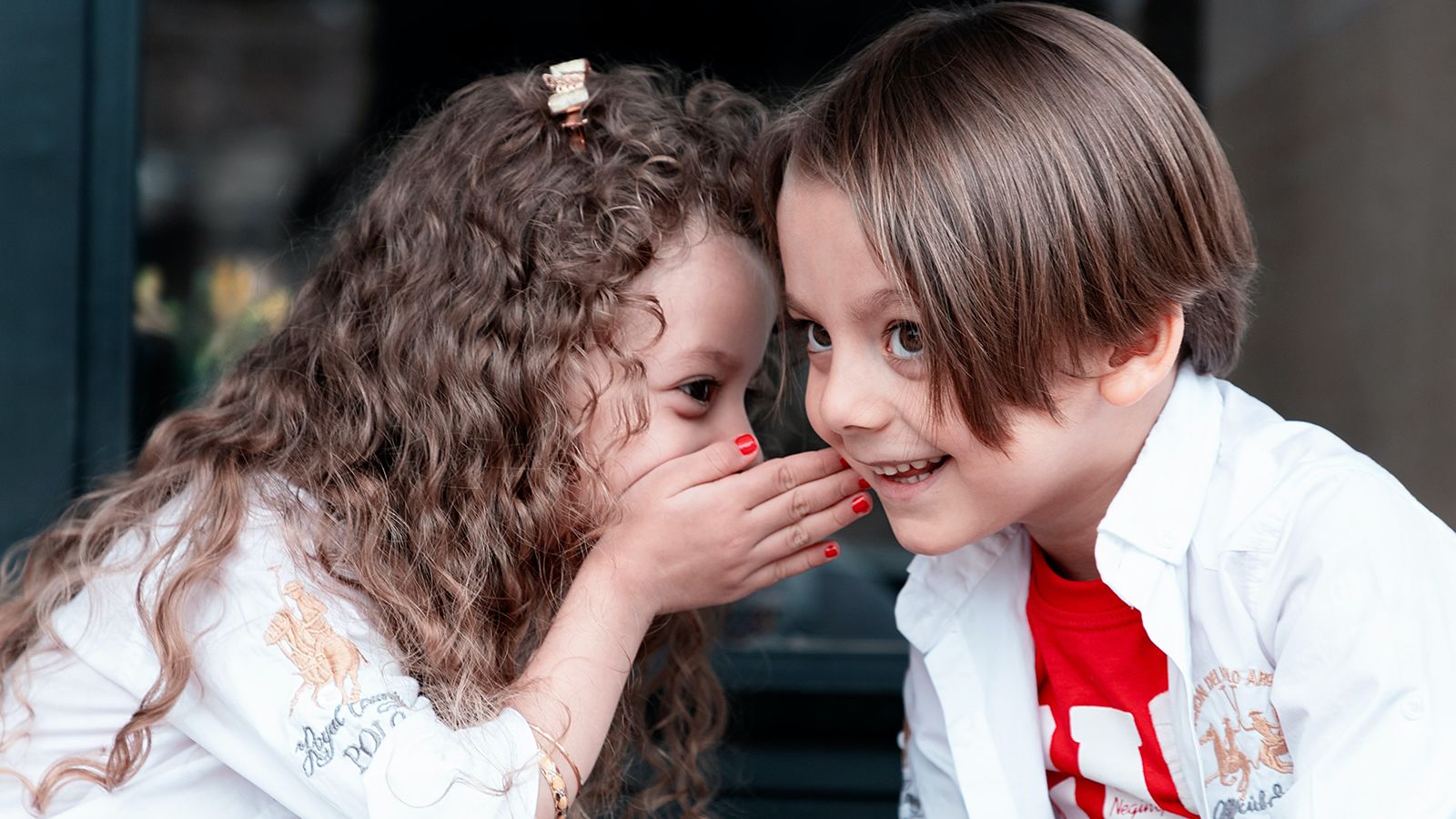 Two children sharing a secret