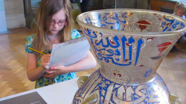Child looking at a vase in a museum